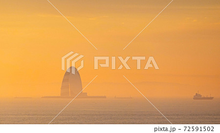 早朝の羽田空港 滑走路から朝焼けの東京湾風の塔 川崎人工島 の写真素材
