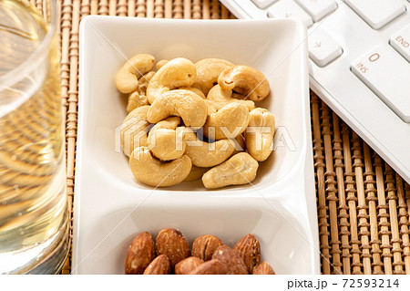 オンライン飲み会イメージ。ナッツとハイボールとパソコンのキーボード。 オンライン飲み会イメージ。ナッツとハイボールとパソコンのキーボード。 72593214