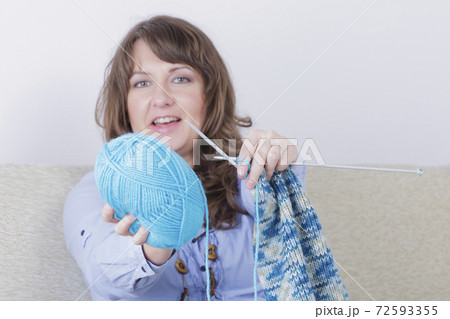 Woman knitting a scarf at home Woman knitting a scarf at home 72593355