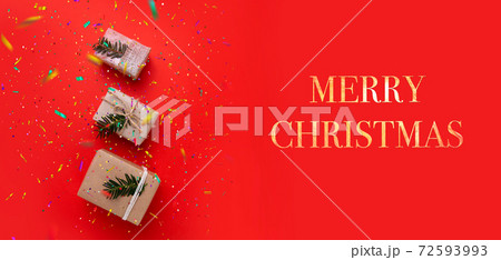 three boxes with gifts on bright red background and inscription Merry Christmas 72593993