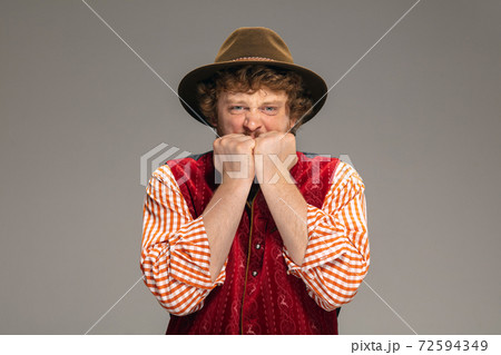 Happy smiling man dressed in traditional Austrian or Bavarian costume gesturing isolated on grey studio background 72594349