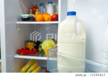 Open fridge full of fruits, vegetables and drinks Open fridge full of fruits, vegetables and drinks 72595827