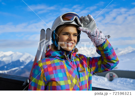 woman skier  wearing white healmet with mask in snow winter mountain 72596321