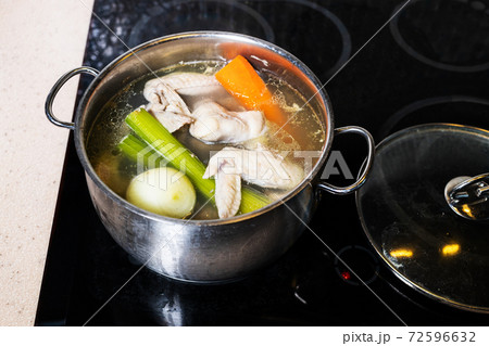 above view of chicken broth in stewpot on stove above view of chicken broth in stewpot on stove 72596632