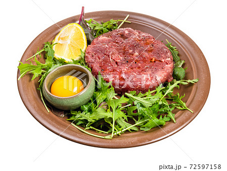 yolk in bowl and Steak tartare on plate isolated 72597158
