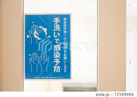 オフィスの入口に貼られた手洗いで感染予防の掲示物 72599008