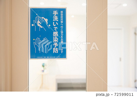 オフィスの入口に貼られた手洗いで感染予防の掲示物 72599011