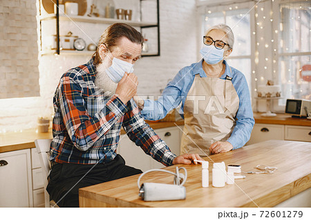 Senior woman and man at home meassure blood pressure Senior woman and man at home meassure blood pressure 72601279