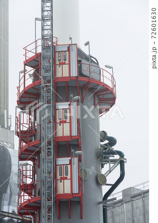 Chimney at heating plant covered in fog, cloudy winter day, low angle view, energy production, air pollution, climate change and global warming concept Chimney at heating plant covered in fog, cloudy winter day, low angle view, energy production, air pollution, climate change and global warming concept 72601630