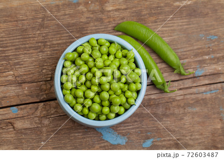 Green peas in blue bowl on vintage gray wooden table background Green peas in blue bowl on vintage gray wooden table background 72603487