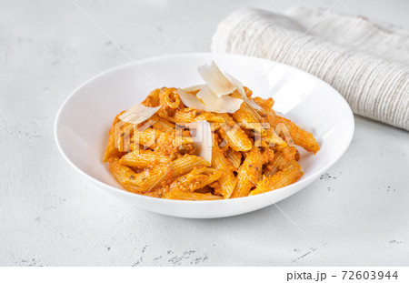 Portion of penne pasta with orange pesto sauce Portion of penne pasta with orange pesto sauce 72603944