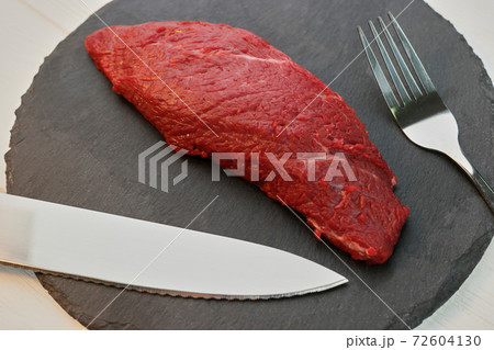 Raw beef steak on a plate. 72604130