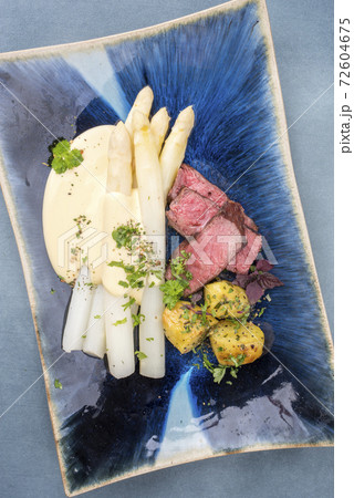 barbecue dry aged sliced fillet steak with white asparagus in hollandaise sauce 72604675