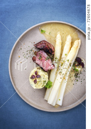 barbecue dry aged sliced fillet steak with white asparagus in butter sauce and mashed potatoes  72604678