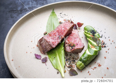 Modern style barbecue dry aged sliced fillet steak with wild garlic and zucchini Modern style barbecue dry aged sliced fillet steak with wild garlic and zucchini 72604701