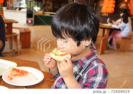 レストランでピザを食べる男の子 72609029