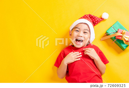 Top view of a kid dressed in red Santa Claus hat Top view of a kid dressed in red Santa Claus hat 72609325