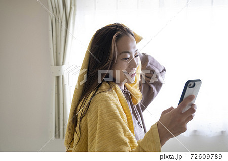 風呂上がりにスマホを見る女性 風呂上がりにスマホを見る女性 72609789