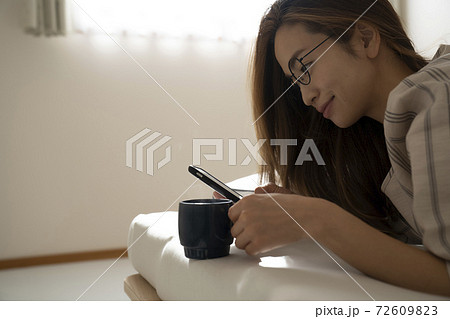 ベッドでコーヒーを飲む女性 72609823