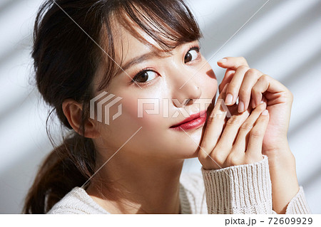 光と影の背景の若い女性のビューティーポートレート 72609929