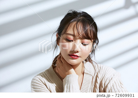 光と影の背景の若い女性のビューティーポートレート 72609931