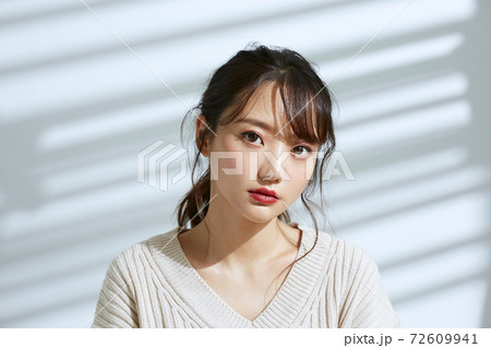 光と影の背景の若い女性のビューティーポートレート 72609941
