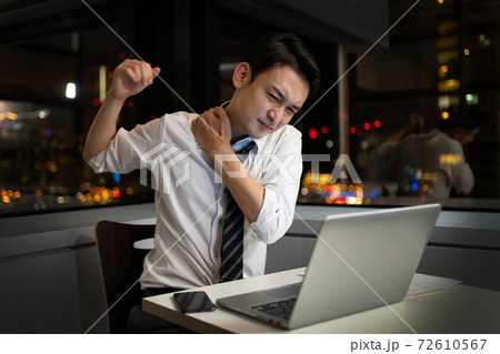 オフィスで夜遅くまで残業をするビジネスマン 72610567