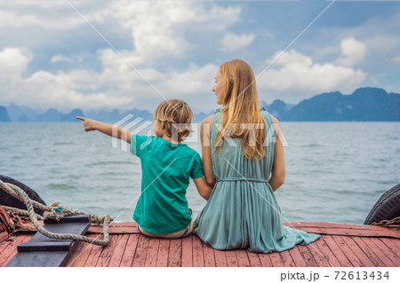Mom and son travelers is traveling by boat in Halong Bay. Vietnam. Travel to Asia, happiness emotion, summer holiday concept. Traveling with children concept. After COVID 19. Picturesque sea landscape Mom and son travelers is traveling by boat in Halong Bay. Vietnam. Travel to Asia, happiness emotion, summer holiday concept. Traveling with children concept. After COVID 19. Picturesque sea landscape 72613434