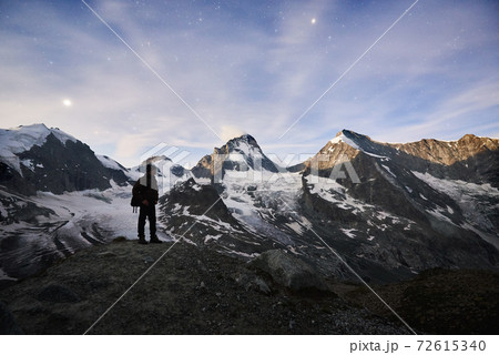 Traveller enjoying incredible starry night in the mountains in Switzerland Alps Traveller enjoying incredible starry night in the mountains in Switzerland Alps 72615340
