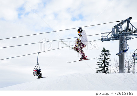 Male skier jumping in the air at ski resort. Male skier jumping in the air at ski resort. 72615365
