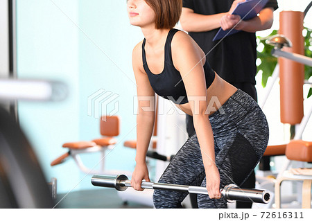 デッドリフトをする若い女性とトレーナー デッドリフトをする若い女性とトレーナー 72616311