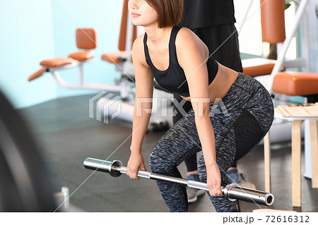 デッドリフトをする若い女性とトレーナー デッドリフトをする若い女性とトレーナー 72616312