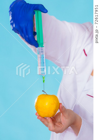 Injection into red apple, genetic modification concept 72617951