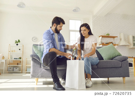 Young married couple received a food delivery and unpacked a package of groceries together. 72620735