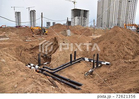 Laying water pipes with insulation of the central heating systems in the ground.  72621356