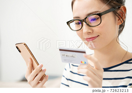 スマートフォンとカードを持つ若い女性 72623213