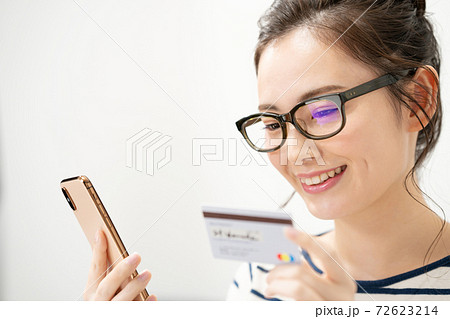 スマートフォンとカードを持つ若い女性 72623214