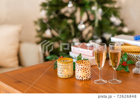 クリスマス ツリーの前のテーブルに並べられたプレゼントとシャンパン クリスマス ツリーの前のテーブルに並べられたプレゼントとシャンパン 72626848