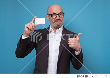 Mature man in business suit showing thumbs up sign showing credit card. 72628287