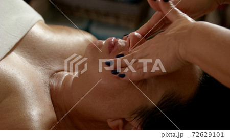Cosmetologist doing skincare treatment to mature woman. Cosmetologist doing skincare treatment to mature woman. 72629101