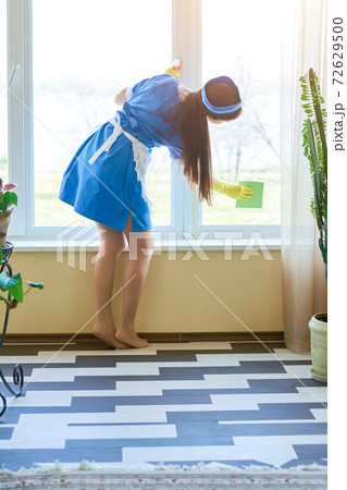 Housemaid cleaning window, back view. Housemaid cleaning window, back view. 72629500