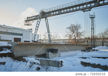 Row of reinforced concrete foundations with metal anchor bolts designed for the installation of metal columns. Foundations of warehouse on the construction site. 72630210
