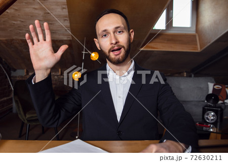 Young man talking, working during videoconference with colleagues at home office 72630211