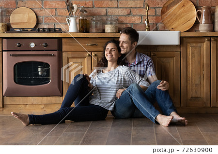 Happy newlyweds moving to new house creating plans at kitchen Happy newlyweds moving to new house creating plans at kitchen 72630900