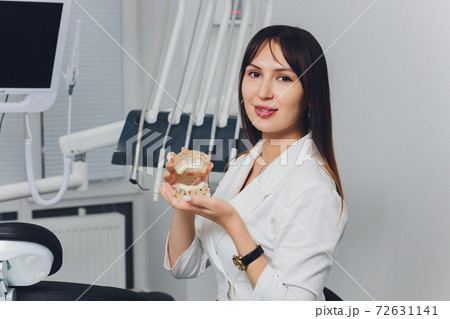 Portrait of attractive smiling female dentist with hands folded. 72631141
