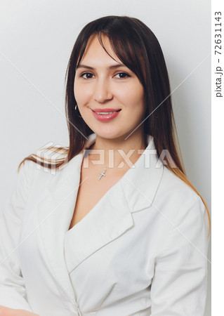 Portrait of attractive smiling female dentist with hands folded. 72631143