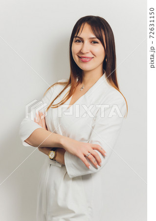 Portrait of attractive smiling female dentist with hands folded. 72631150