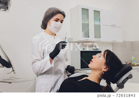 Dentist and patient choosing treatment in a consultation with medical equipment in the background. 72631843