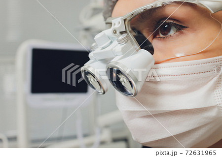 feMale dentist in special glasses with magnifying glasses and mask. Medical worker. 72631965