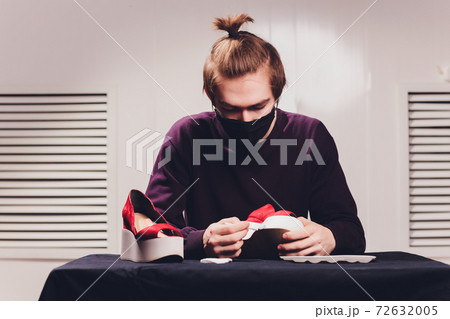 close up cropped photo. man painting with a tip of the brush, focus on the cloth, leather. close up cropped photo. man painting with a tip of the brush, focus on the cloth, leather. 72632005